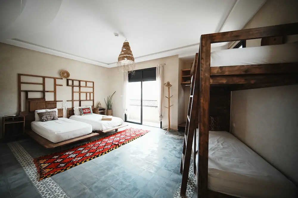 The female dorm, with beds along the wall and a window at the end