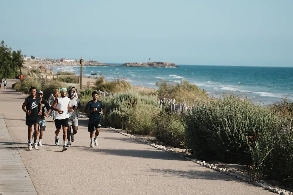 Surfers Running on the Beach - Run Club Tamraght at The Yogi Surfer in Taghazout Bay, Morocco.