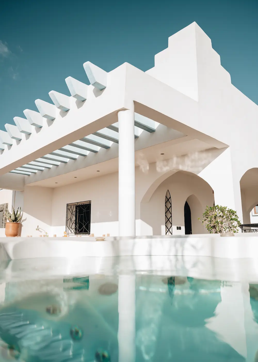 The hot tub water, with the white terrace arches reflected in it