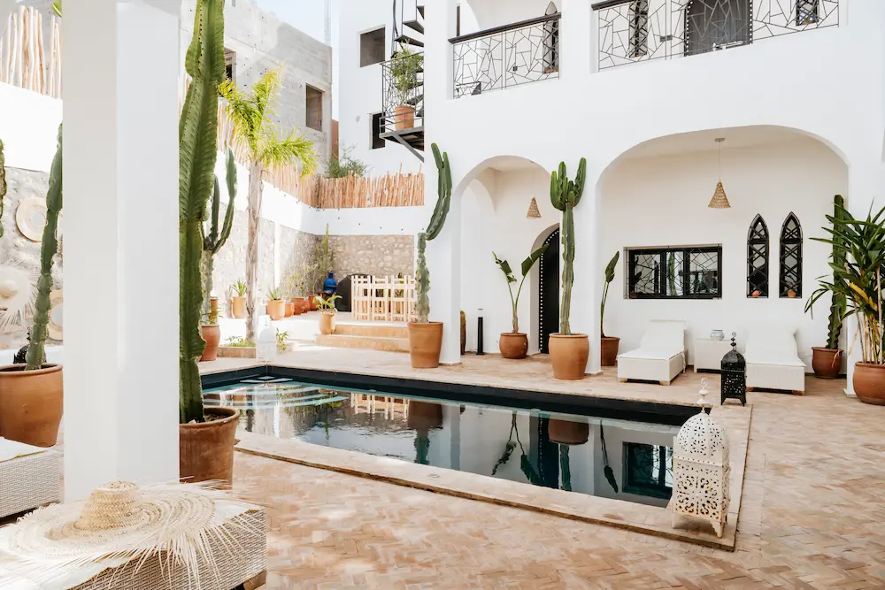 The pool courtyard, with cacti, white arches and sunlit tiled flooring