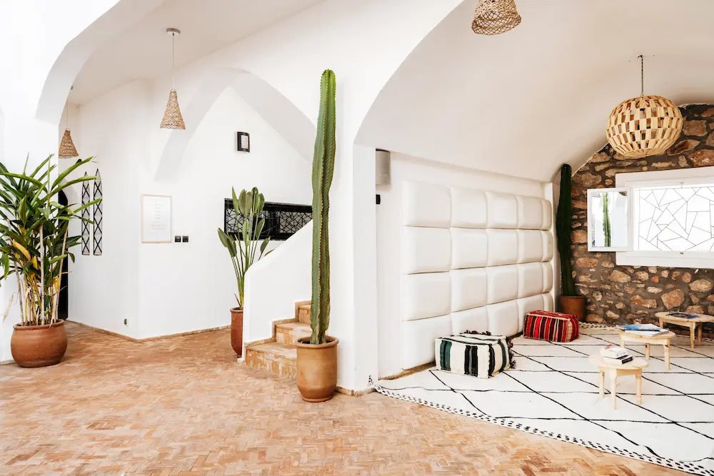 The terrace lounge, with white arches, cacti and woven pendant lights