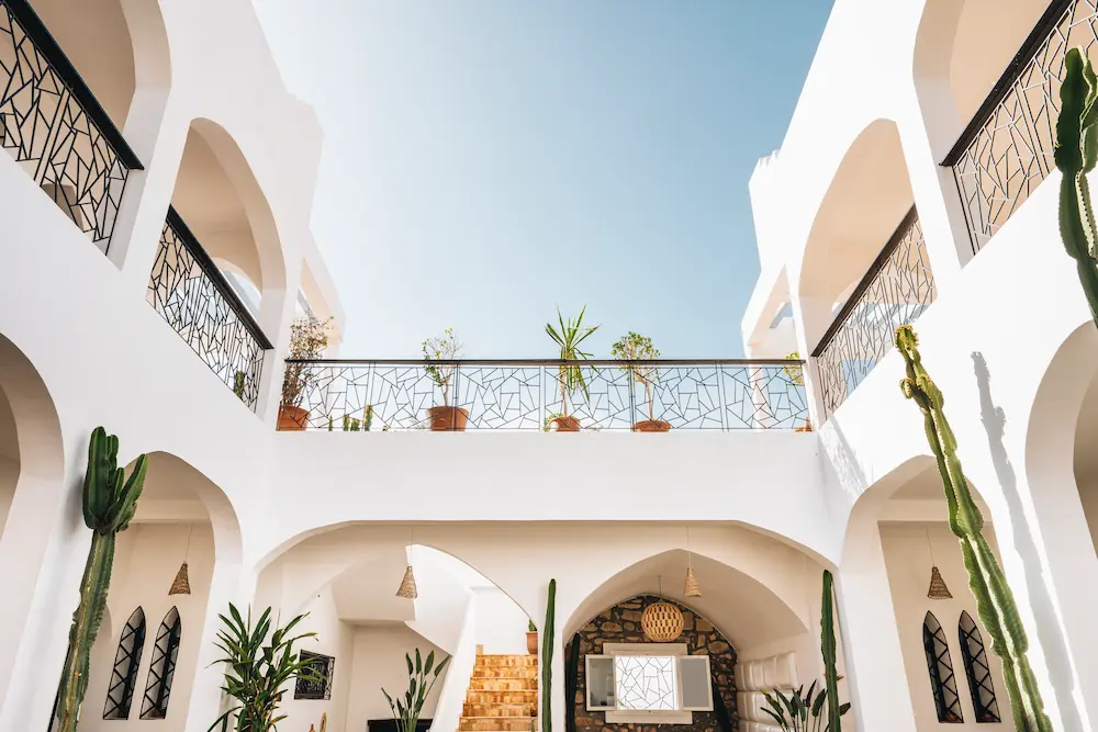 The whitewashed courtyard seen from below, with arches and black railings above